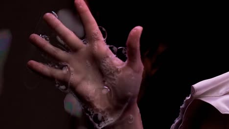 trucos en cámara lenta de primer plano con burbujas de jabón la niña mueve sus dedos juega con la mano en la pantalla de jabón