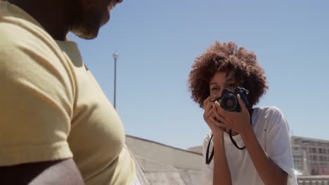 woman taking photo of man with digital camera on the beach 4k