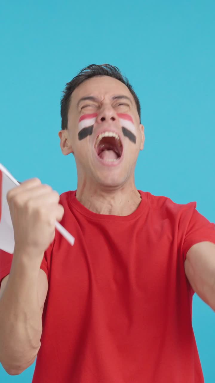 Man cheering for Egypt screaming and waving a national flag