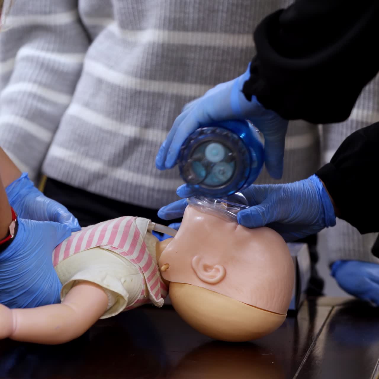 Practical medical course on a mannequin. Practitioners doing cardiopulmonary resuscitation on a baby doll. Chest compression and breathing. CPR medical training