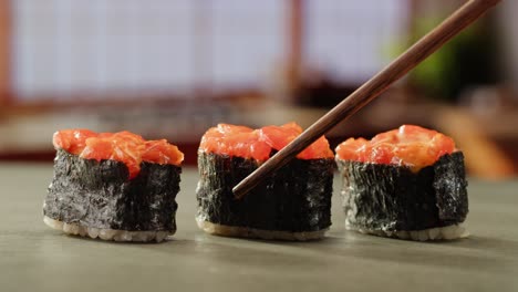 closeup of sushi rolls with chopsticks