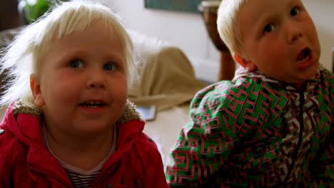 Siblings-sitting-together-in-living-room-at-home-4k