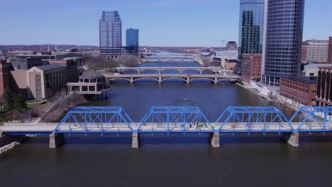 forward aerial of blue bridge, grand river and grand rapids skyline