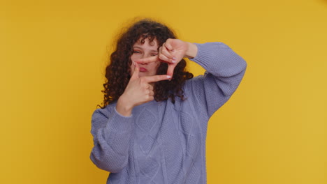 Woman-photographer-gesturing-picture-frame-with-hands,-looks-through-fingers-and-focusing-on-object