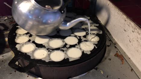 concepto de cocina. tipo de carne dulce tailandesa. leche de coco mezclada con postre frito en polvo en el mercado de comida callejera tailandés de la noche. postre de carne tradicional tailandesa, panqueque, pudín. imágenes de 4k.