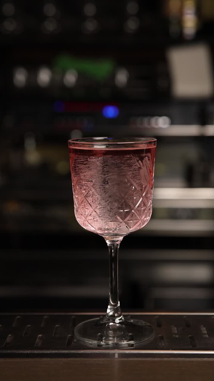 el camarero preparando un cóctel rosa.