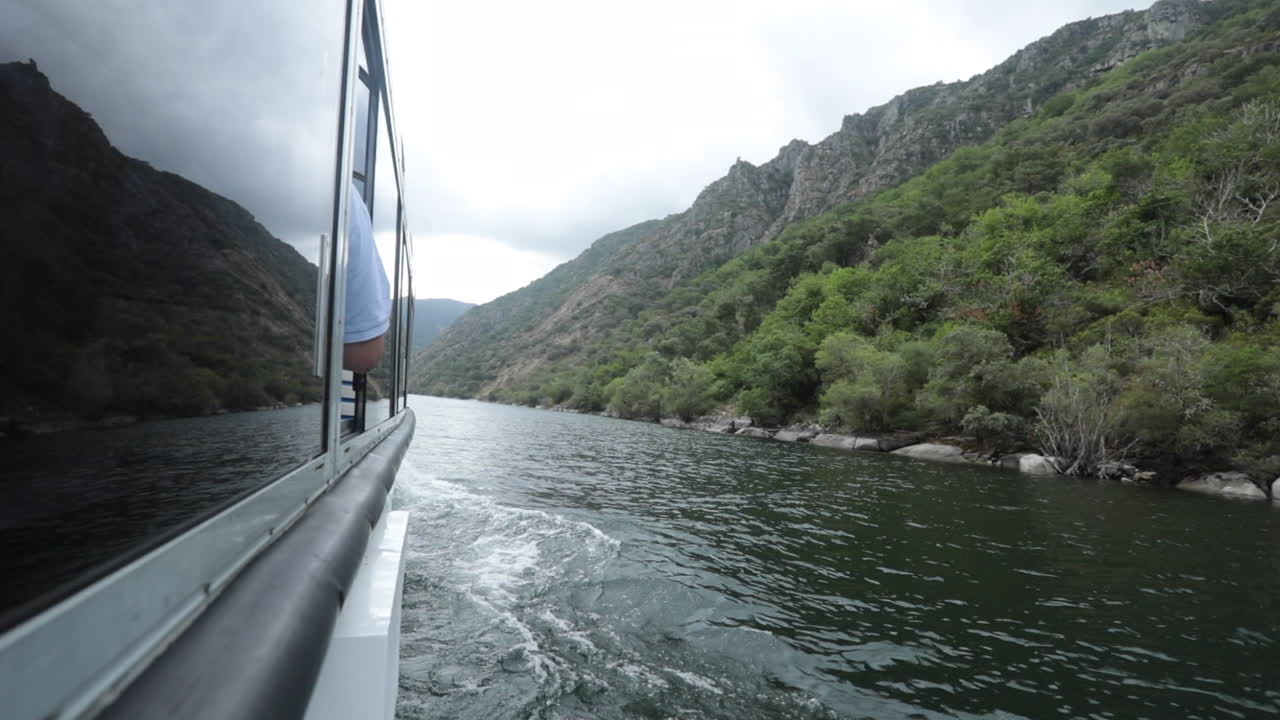 paseo en barco por el cañón de sil en galicia, españa, pasando por colinas verdes y acantilados en un día nublado