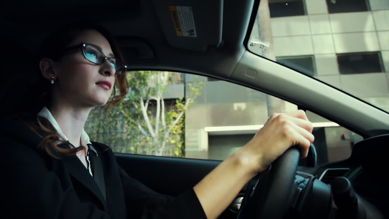 mujer de negocios conduciendo con una expresión neutral