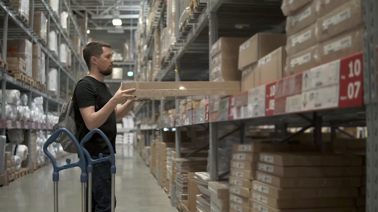 hombre recogiendo artículos de los estantes del almacén