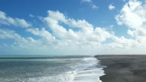 aerial reverse with cloud shadows on turbulent ocean at birdlings flat beach