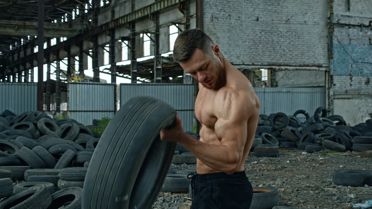 Man training with tire. Muscular fitness man training with old tire wheel