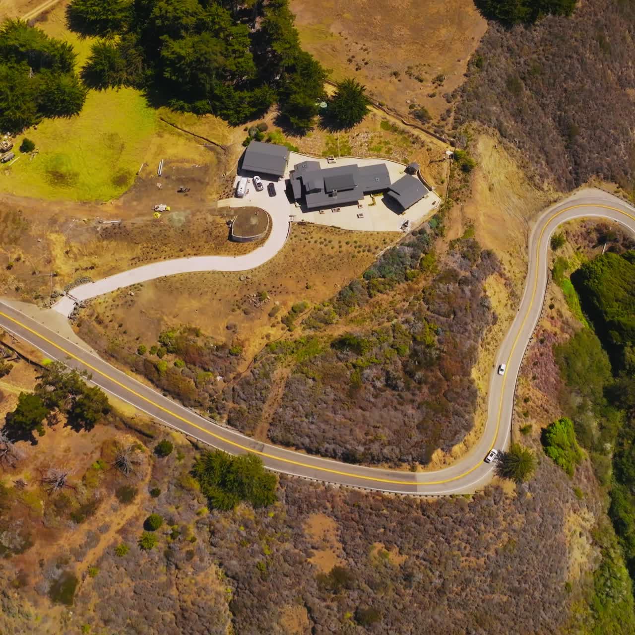 Cozy hotel situated on the rocky shore of Morro Bay. White ways splashing on the craggy rocks of coastline. Top view
