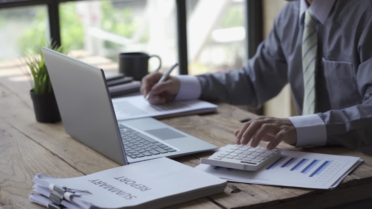 Empresário desenvolvendo projeto de negócios e analisando dados de gráficos de marketing com documentos contábeis e relatórios financeiros em mesa de vídeo 4K