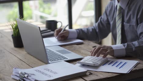 businessman developing business project and analyzing marketing graph data with accounting documents and financial reports on 4k video table.