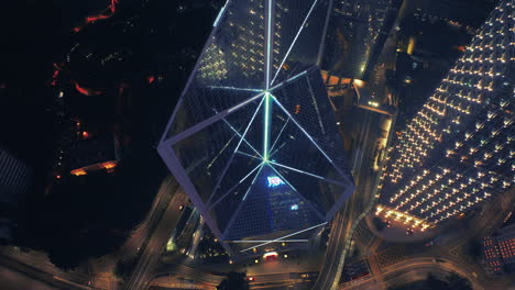 Toma-Aérea-Desde-Arriba-De-Luces-De-Neón-Intermitentes-En-El-Edificio-Del-Banco-De-China-En-La-Ciudad-De-Hong-Kong-Por-La-Noche