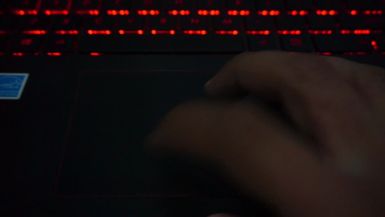 haga que el dedo se mueva en el puntero del portátil con el fondo de la luz del teclado