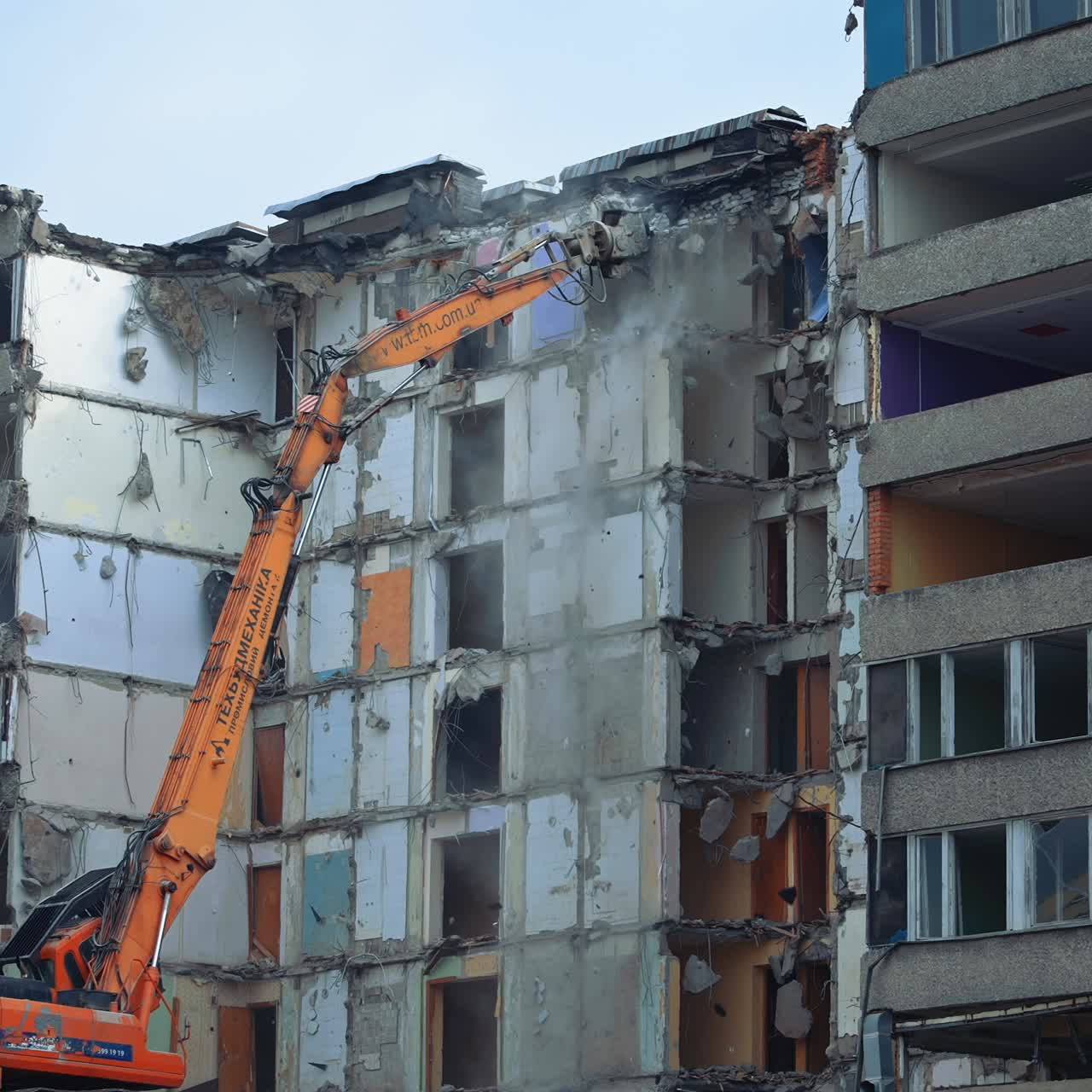 Demolition Of Old Residential Building. Destroying Old Concrete Building Using Mechanical Arm of Bulldozer on Construction Site