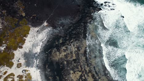 Aerial-view-of-black-sand-beach-and-turquoise-ocean-waves