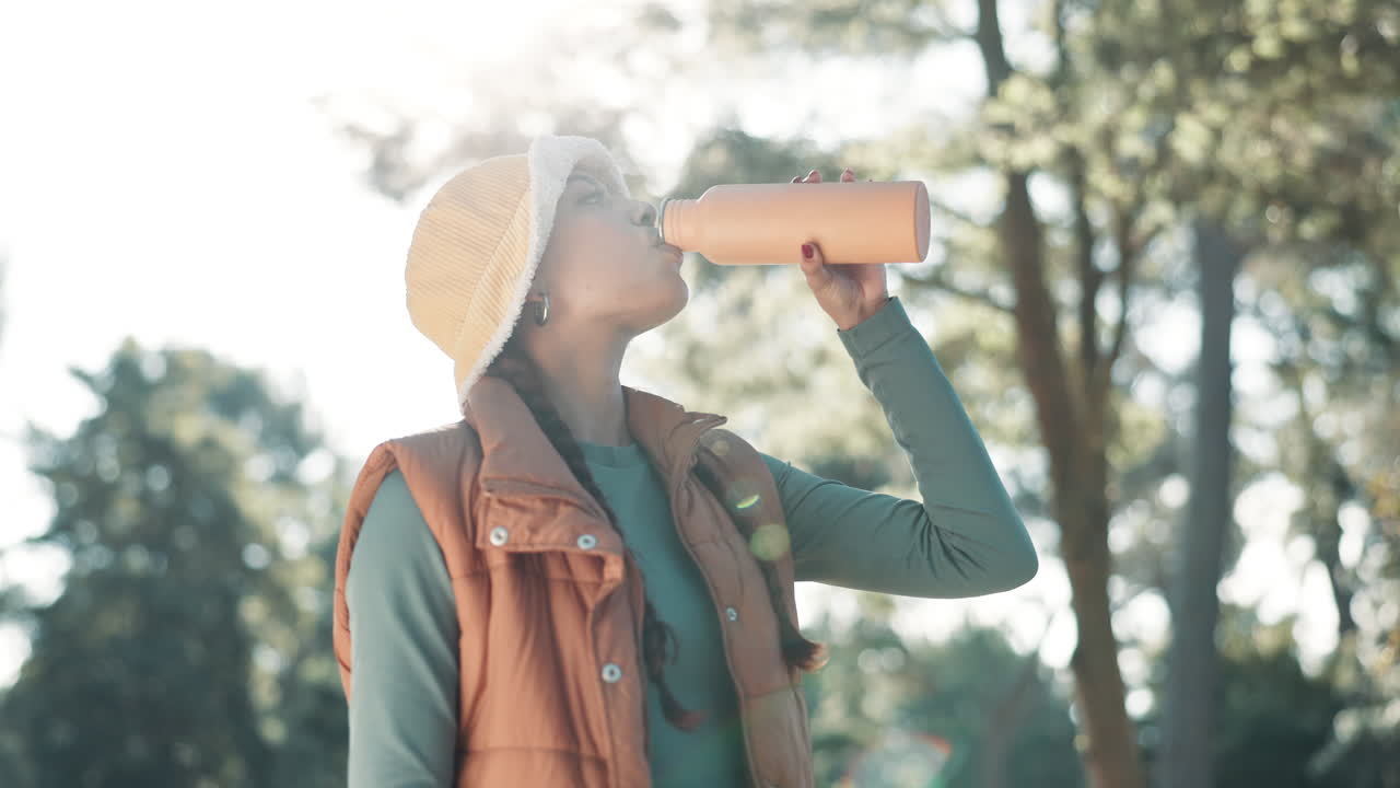 Woman drinking from water bottle outdoors