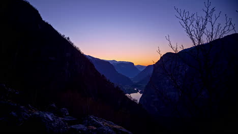 tiro de lapso de tiempo de la ladera de la montaña en el fiordo noruego en llamas, noruega oscureciendo al atardecer