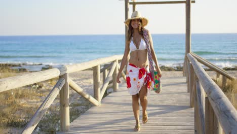mujer sonriente en un paseo marítimo de madera