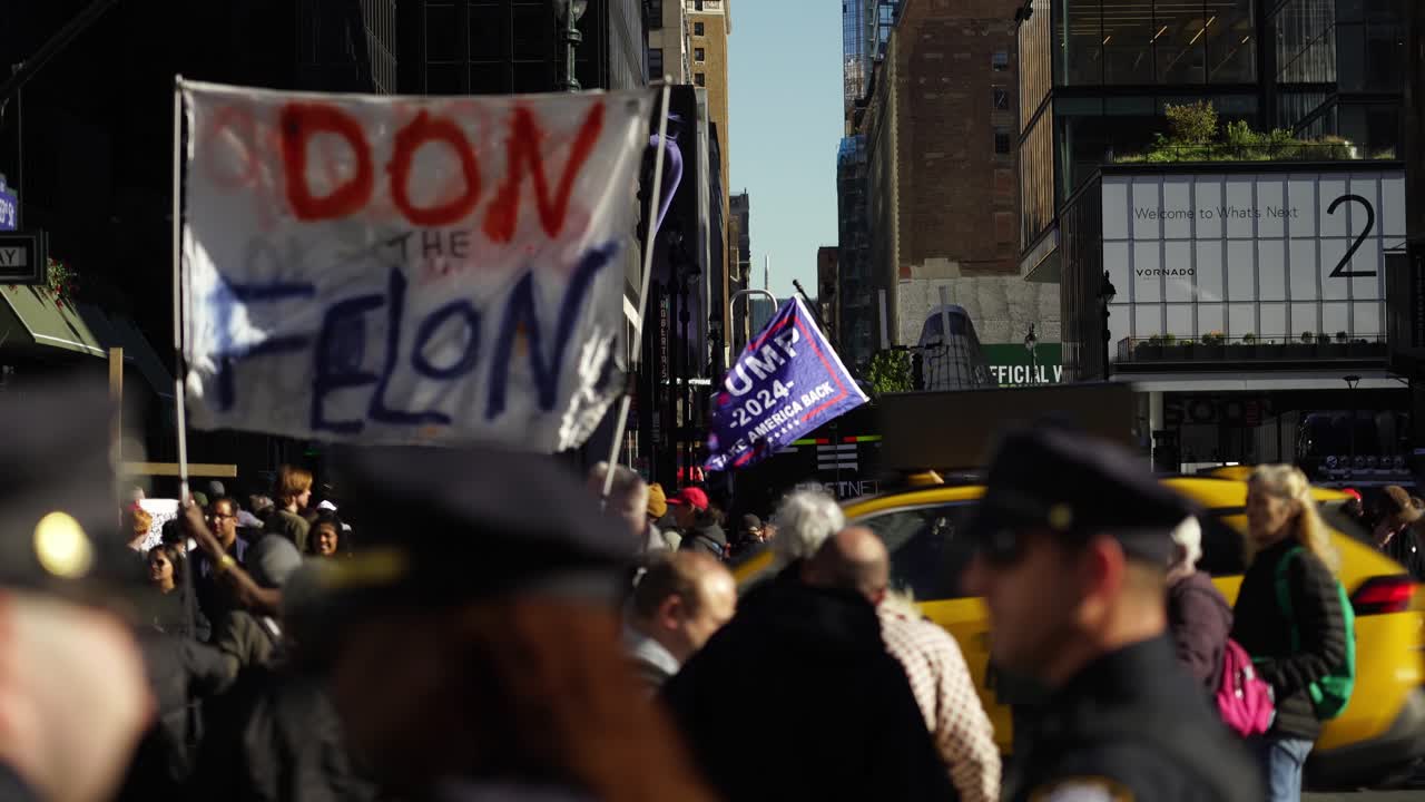 The flag bearing the Trump name waves in slow, rhythmic motion under the radiant New York sun, creating a striking visual