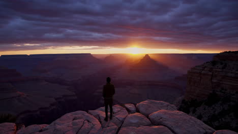 person observing a dramatic sunset over the grand canyon