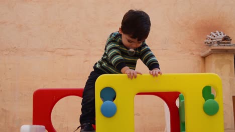 Lindo-Niño-De-Dos-Años-Deslizándose-Por-El-Tobogán-De-Plástico-En-El-Patio-Trasero