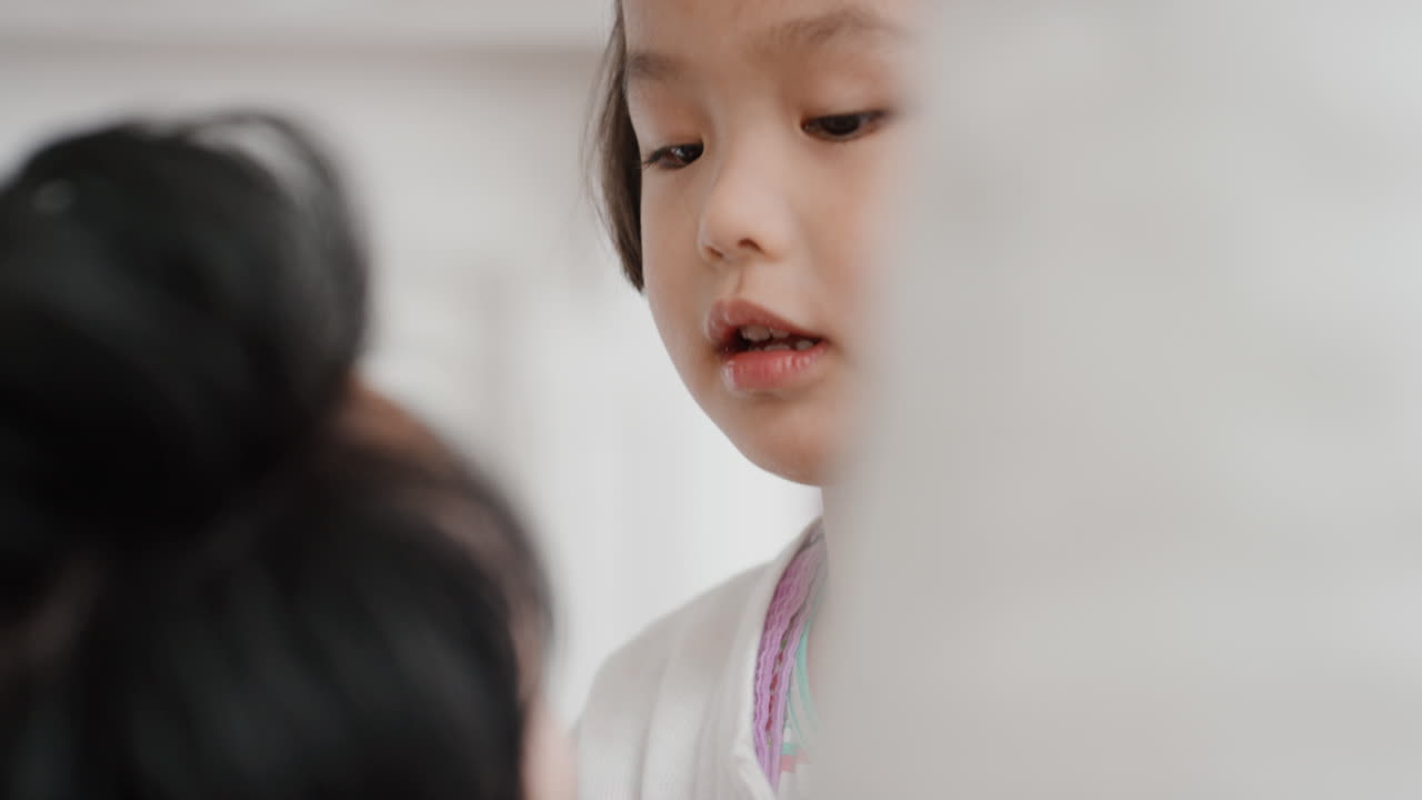 아버지와 함께 아름다운 작은 아시아 소녀가 집에서 딸과 함께 놀고 있는 가족 시간을 보내고 있습니다.