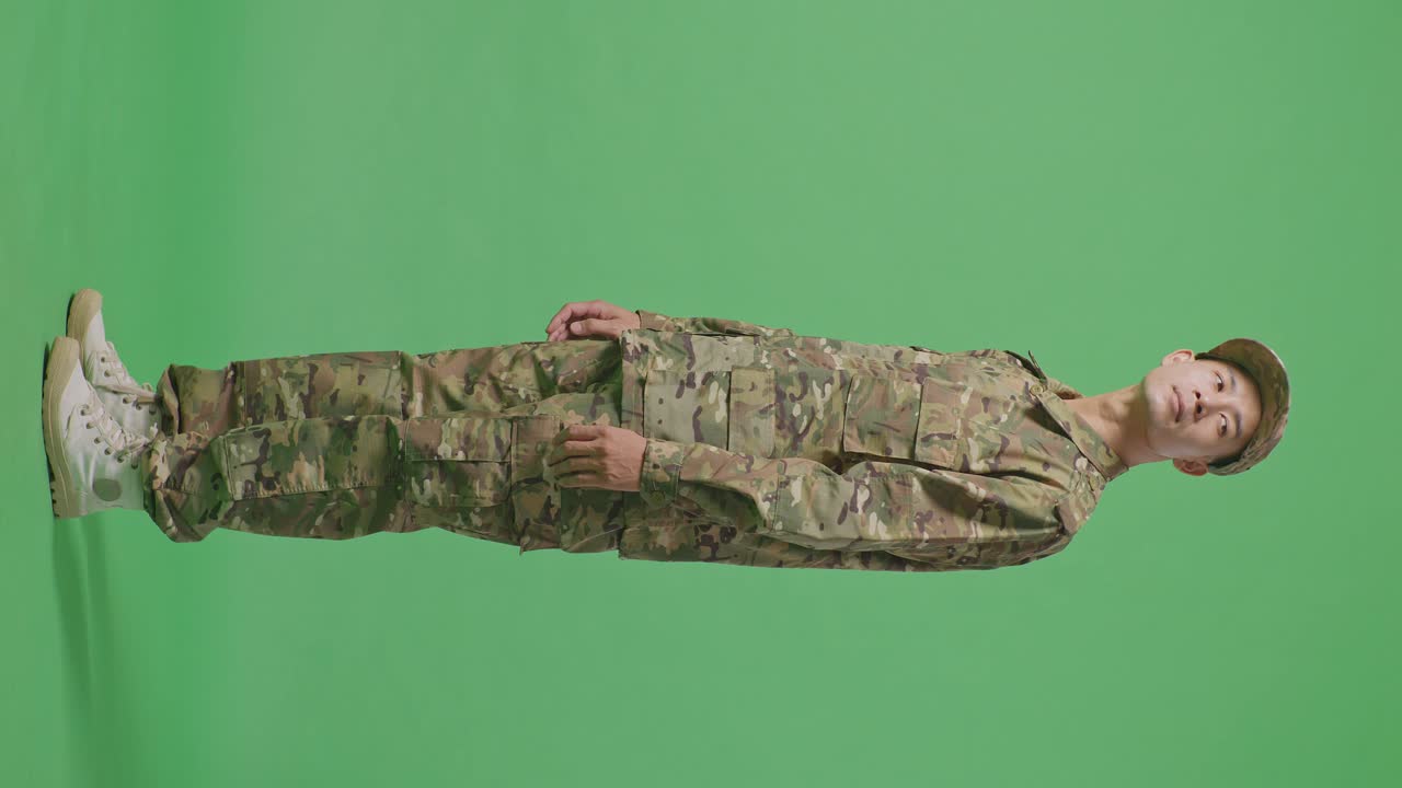Full Body Of Side View Asian Man Soldier Looking Around While Standing In The Green Screen Background Studio