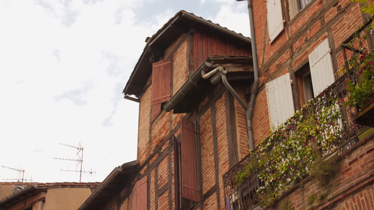 Close view of a traditional timber-framed facade with shutters and balcony in Albi’s historic center