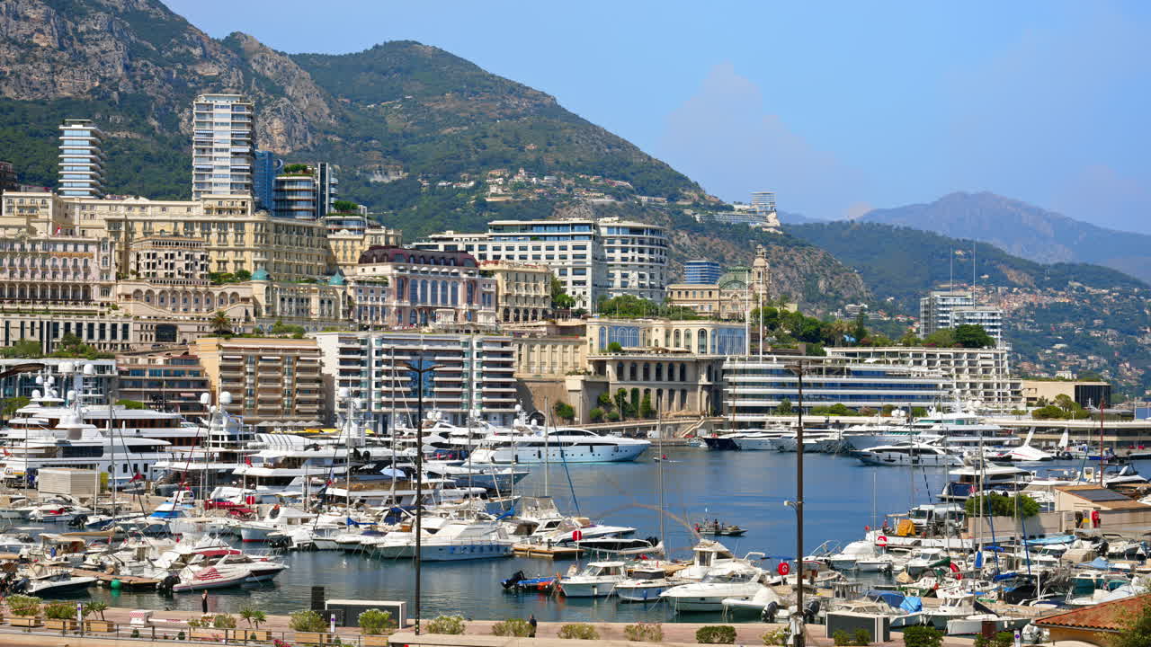 View of boats docked in the Monaco Marina with the skyline of the city on the background