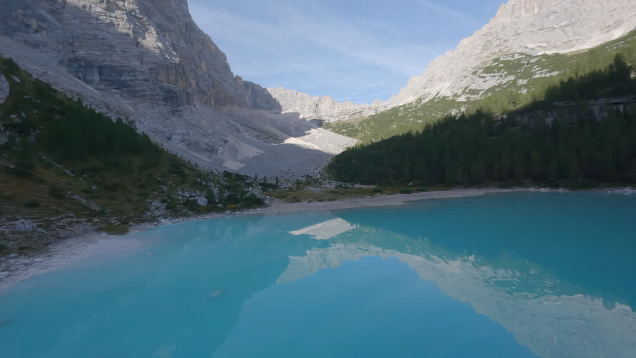 las dolomitas se reflejan en el lago de color azul en italia, vista rápida de drones fpv