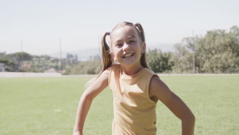 portrait of happy caucasian girl on sunny elementary school playing field, slow motion