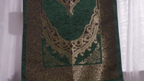 close up of muslim woman at home laying down prayer mat on floor 3