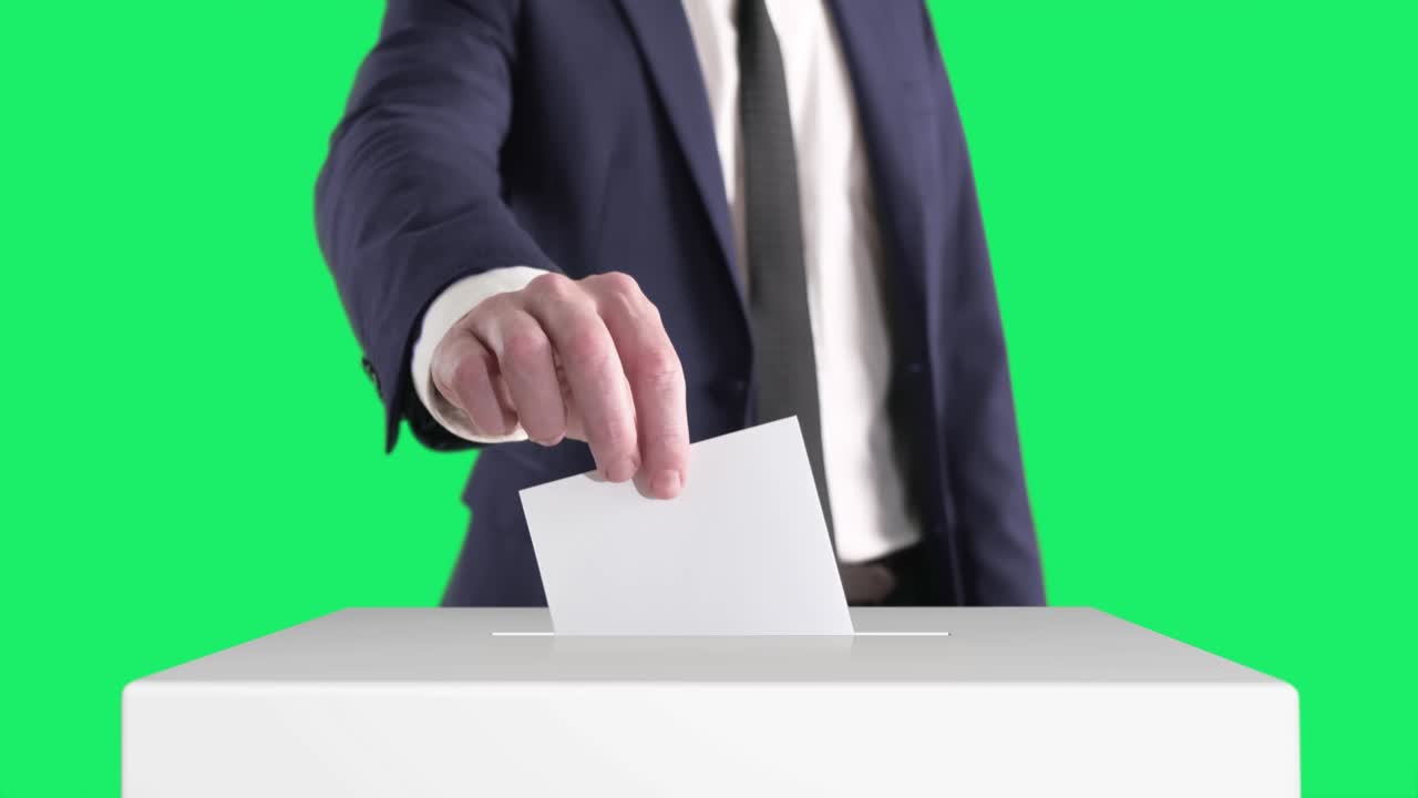 투표. 남자가 배경에 크로마 키가 있는 투표 상자에 투표용지를 넣고 있습니다.