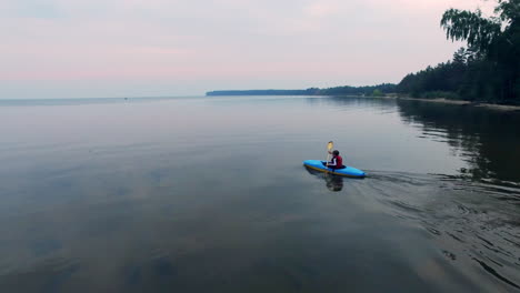 дронный вид молодого спортсмена, катающегося на каноэ в море