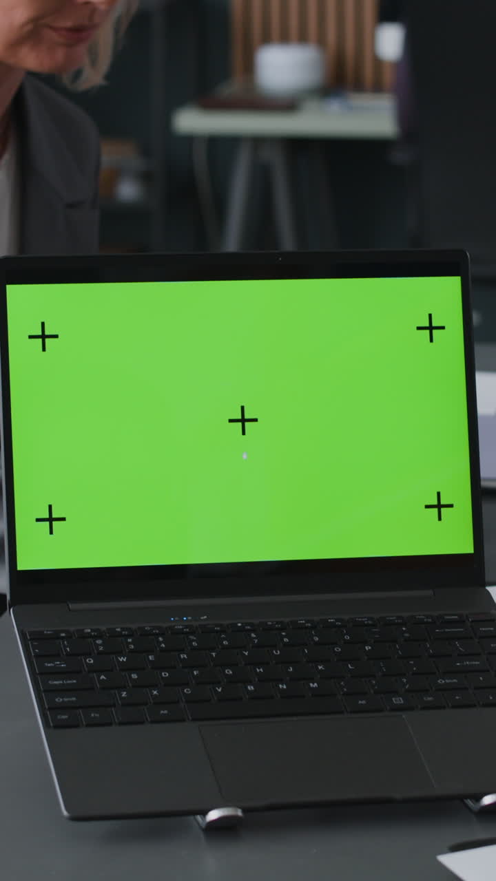 Businesswoman using laptop with green screen