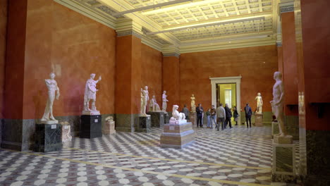 hall with statues and visitors of the hermitage museum in st. petersburg, russia