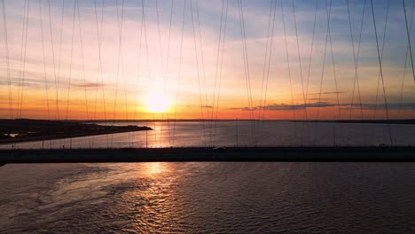 sunset's allure: aerial view of humber bridge with cars in motion