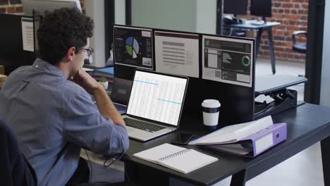 Caucasian-man-sitting-at-desk-coding-data-on-laptop