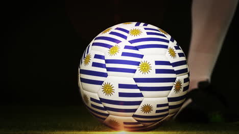 jugador de fútbol pateando la pelota de la bandera de uruguay