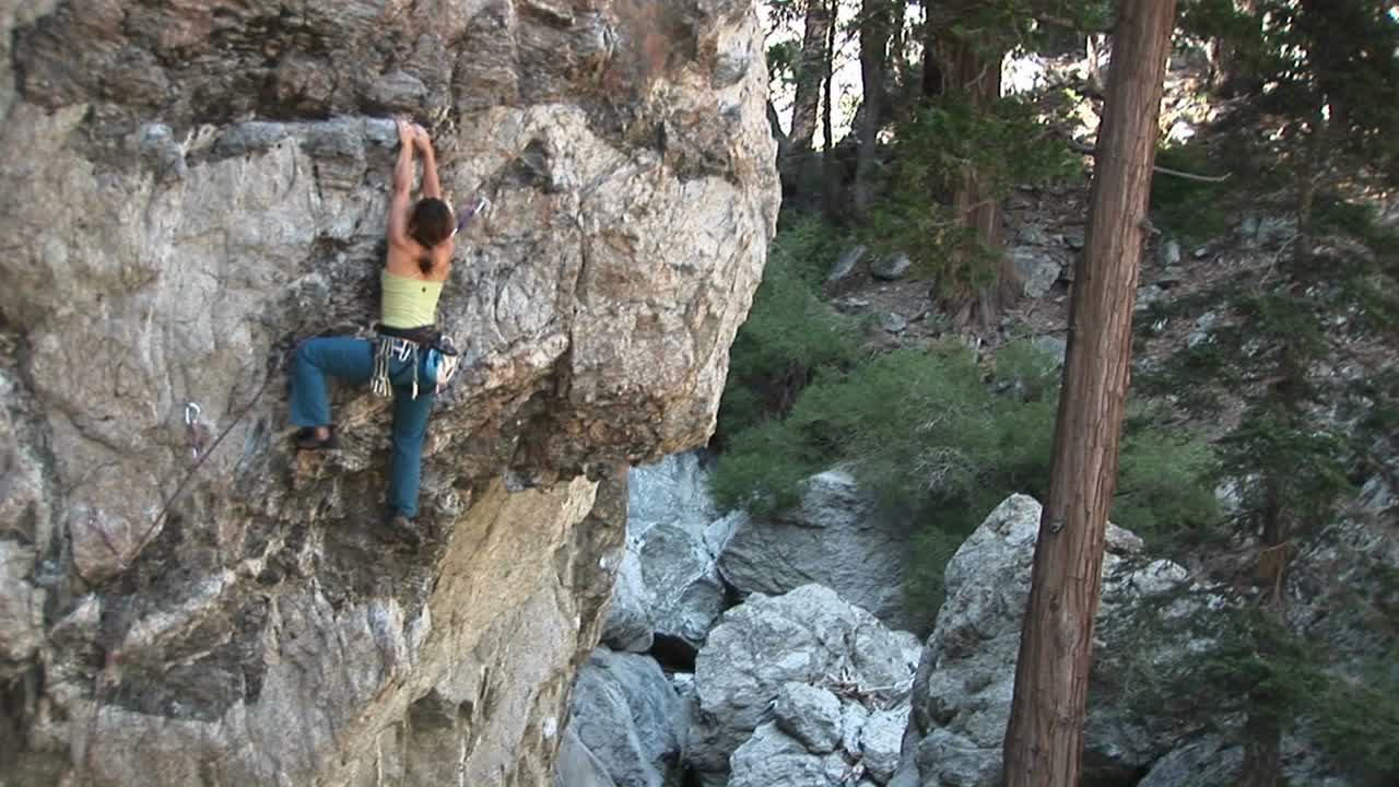 panup de un escalador que sube por un acantilado de roca perpendicular