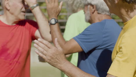 two opponent football teams greeting and giving five to each other before match