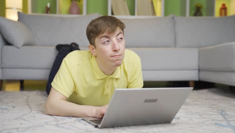 joven exitoso en casa en la computadora portátil.