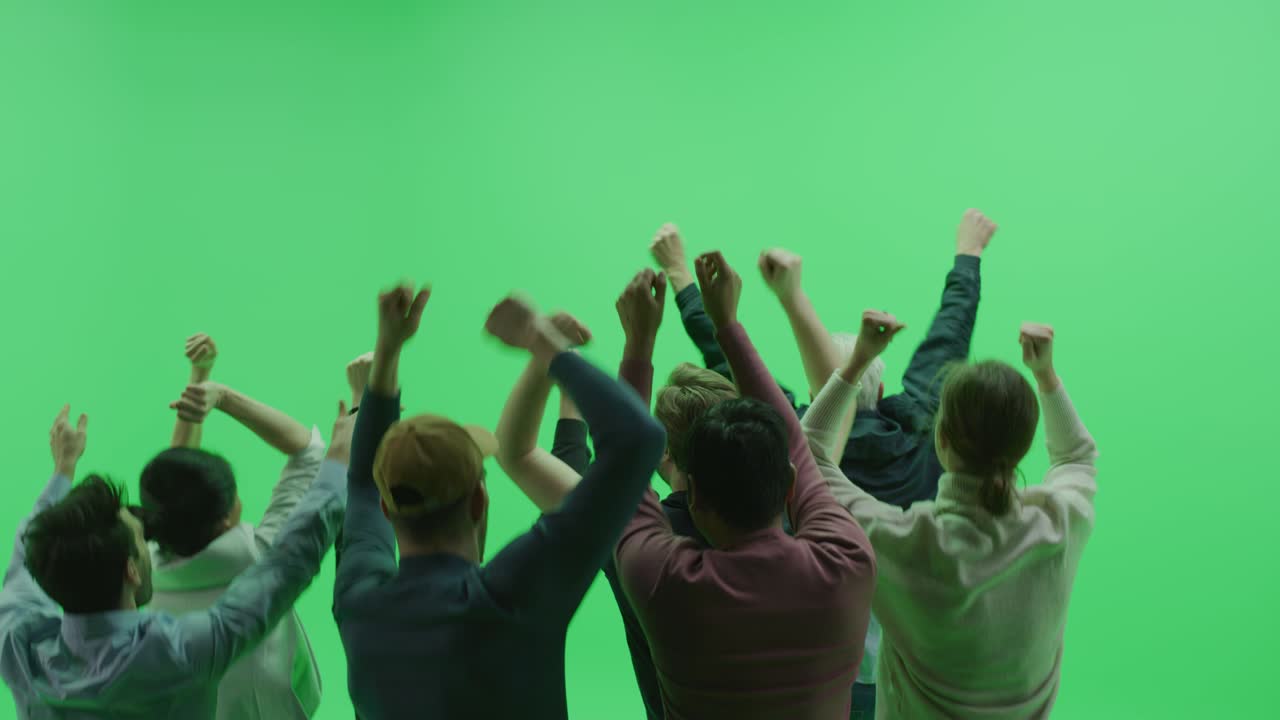Green Screen Chroma Key Studio: Diverse Crowd of Fans Cheering, Screaming, Jumping, Clapping and Applauding at the Public Sport Event, Concert, Festival, Party. Back View Medium Shot. Slow Motion