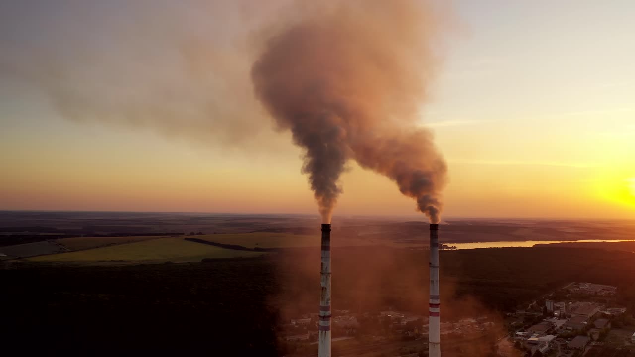 City air pollution. Plant and chimney stack with smoke and dirty orange air as illustration for pollution and importance of climate
