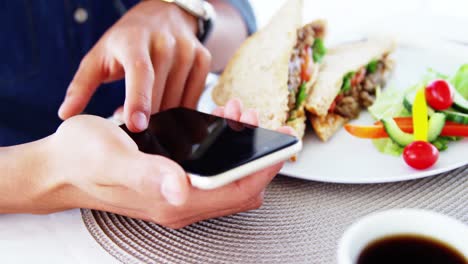 Hombre-En-La-Barra-Del-Almuerzo-Con-Teléfono-Inteligente-Y-Café