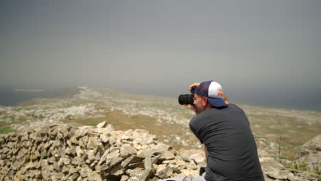 One-man-takes-pictures-on-a-high-point-of-Santorini-island-in-Greece