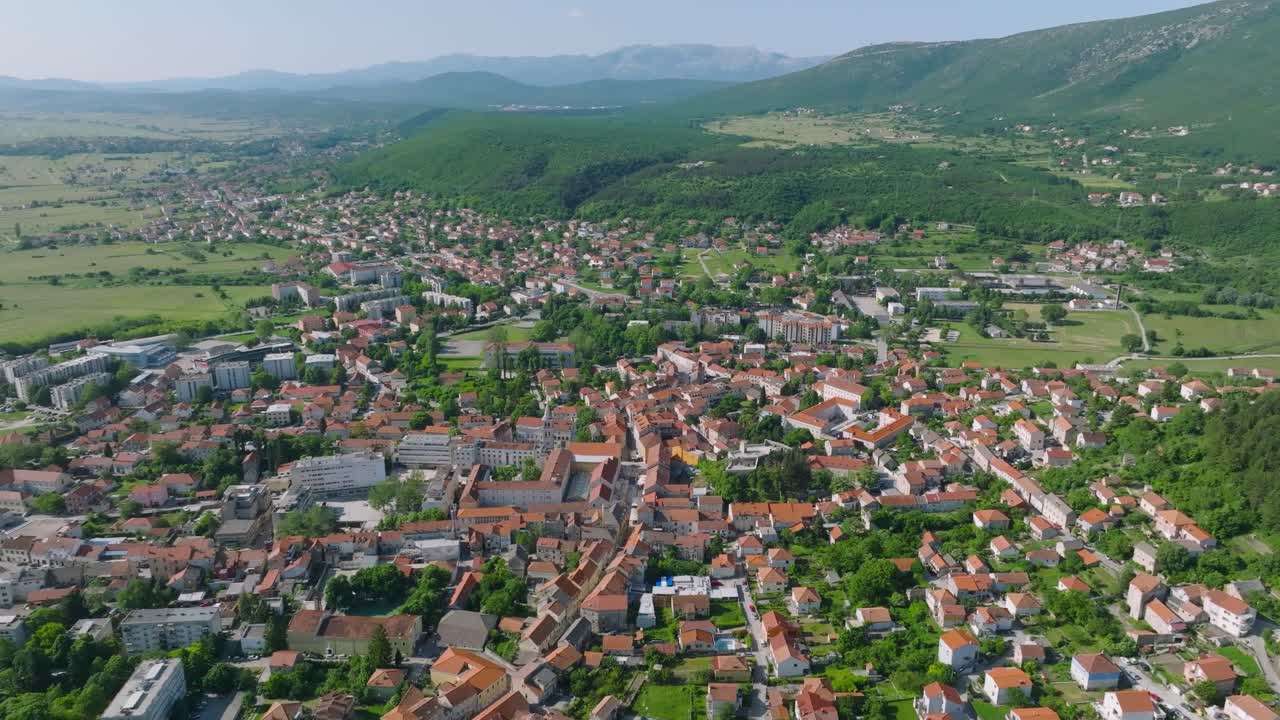 A smooth flyover of the city of Sinj, Croatia on a bright clear day